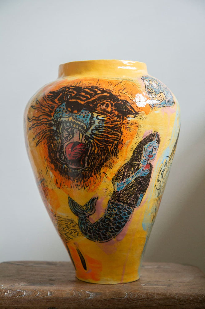 Large yellow ceramic vase decorated with a tiger's face, a mermaid and a skull 