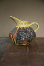 Yellow ceramic jug decorated with a sgraffito design image of a skull and tiger