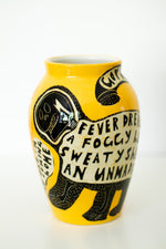 Yellow ceramic vase with black and white sgraffito design as decoration