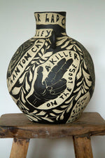 large ceramic vase decorated with a black and white sgraffito design of a hand