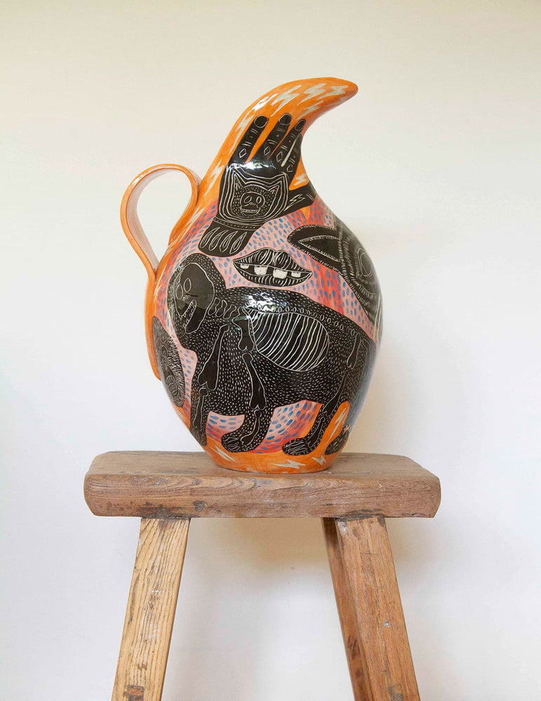 Large orange and black ceramic vase decorated with sgraffito skull and tattoo design