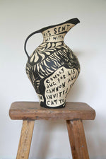 large ceramic jug with a black and white sgraffito design of a tiger and flowers 